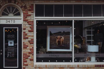 A picturesque vintage café storefront with a brick facade, featuring unique decor and signage.