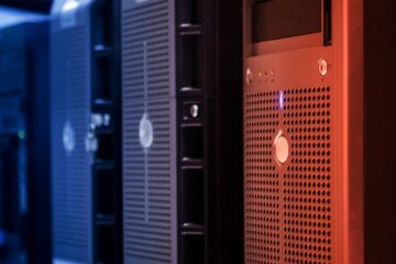 Close-up of tower servers in a data center with blue and red lighting.