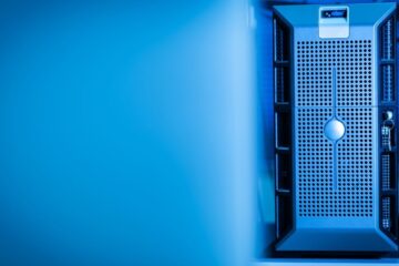 Close-up of a modern server unit in a blue-lit data center environment.