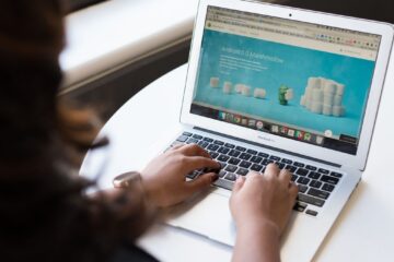 Businesswoman working on laptop with Android 6.0 Marshmallow webpage open.