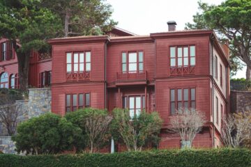 A picturesque red house surrounded by greenery in an urban setting in Istanbul, Turkey.
