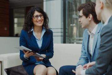 Professionals discussing business strategy in a corporate office setting.